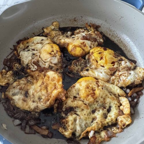 fried eggs cooked in sweet sauce in a medium size pan